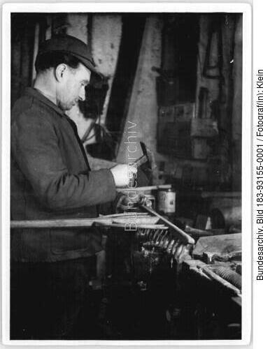 Bauer bei der Reparatur einer Harke